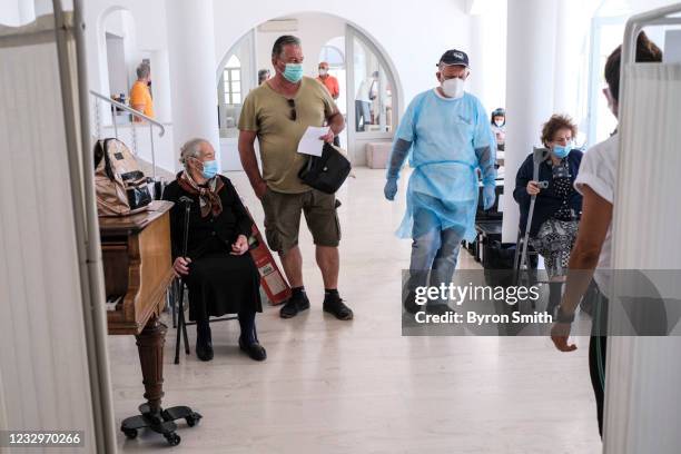 Local residents wait to be seen by doctors from the Aegean Team NGO, who are visiting the remote island areas of the country for 10 days, on May 17,...