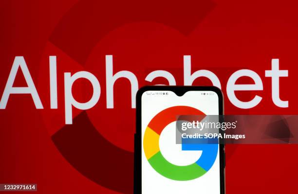 In this photo illustration Alphabet Inc. And Google logo seen displayed on a smartphone.