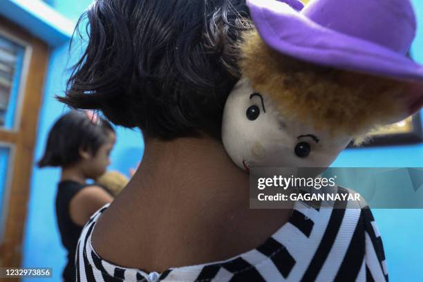 In this picture taken on May 11 twin sisters Tripti and Pari, who lost both their parents due to the Covid-19 coronavirus, play with their toys at a...