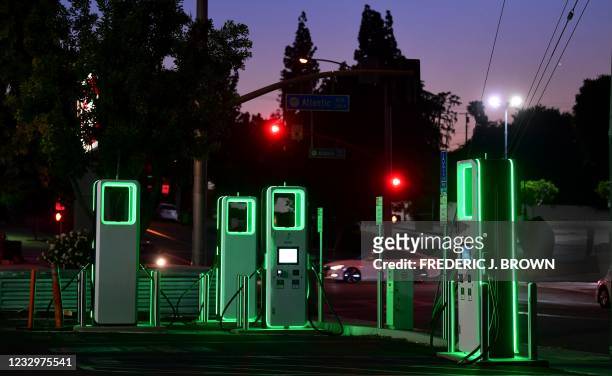 An Electric Vehicle charging station lights up green in the parking lot of a Ralph's supermarket in Monterey Park, California on May 18, 2021. -...