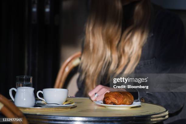 Pan au chocolat pastry and coffee on a customer's table at the reopened Les Deux Magots cafe terrace in Paris, France, on Wednesday, May 19,...