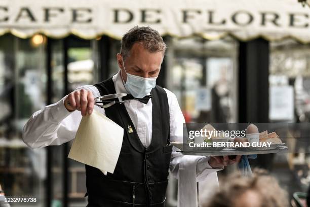 Waiter works at the terrace of Paris' landmark Cafe de Flore on May 19 as restaurant and bar terraces reopen today at 50-percent capacity for groups...