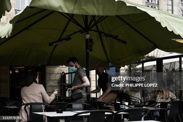 Customer pays at the outdoor terrasse of a cafe restaurant in Bordeaux on May 19 as cafes, restaurants and other businesses re-opened after closures...