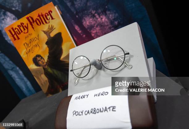 Harry Potter's eyeglasses are exhibited by a copy of "Harry Potter and the Deathly Hallows" during a press preview of Prop Store's Iconic Film & TV...