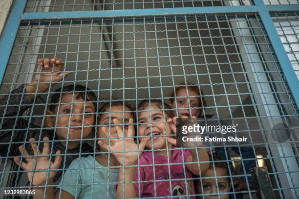 Palestinian children are seen in a UNRWA school, where some families are now living, following Israeli raids on the northern city of Beit Hanoun in...