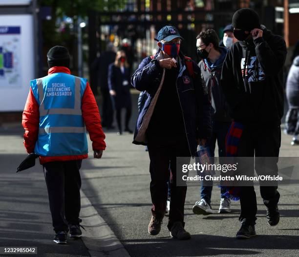 Steward wearing a vest with the title of Social Distancing Ambassador walks past fans ahead of the Premier League match between Crystal Palace and...