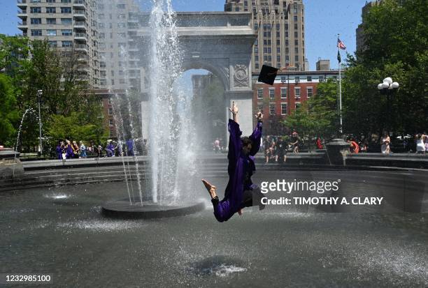 Gabriel Columbo from Brazil jumps in the air in the fountain at Washington Square Park on May 19, 2021 in New York, after the New York University...