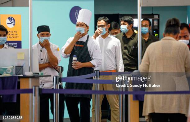 Crewman from a Holland America cruise ship wait in line to receive a Pfizer Covid-19 injection on May 19, 2021 in San Diego, California. 126 Crew...