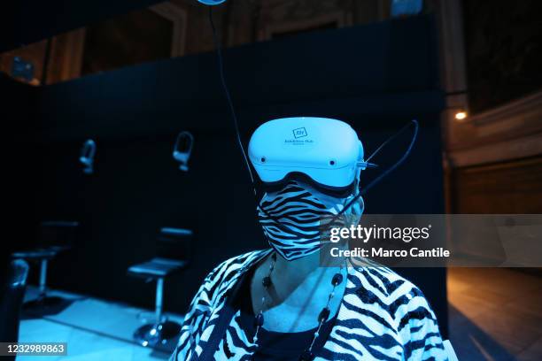Visitor, with a mask to protect himself from Covid-19, wears virtual reality glasses, inside the exhibition "Monet: The Immersive Experience", in...