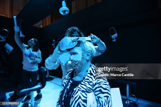 Visitor, with r mask to protect himself from Covid-19, wears virtual reality glasses, inside the exhibition "Monet: The Immersive Experience", in...