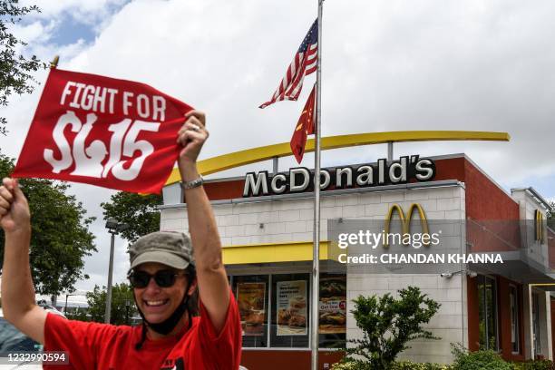 An employee of McDonald's protests outside a branch restaurant for a raise in their minimum wage to $15 an hour, in Fort Lauderdale on May 19, 2021....