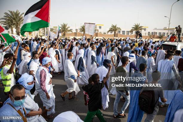 Protesters carry the Palestinian National Flag during a march in support of the Palestinian people in Nouakchott on May 19, 2021. - Deafening air...