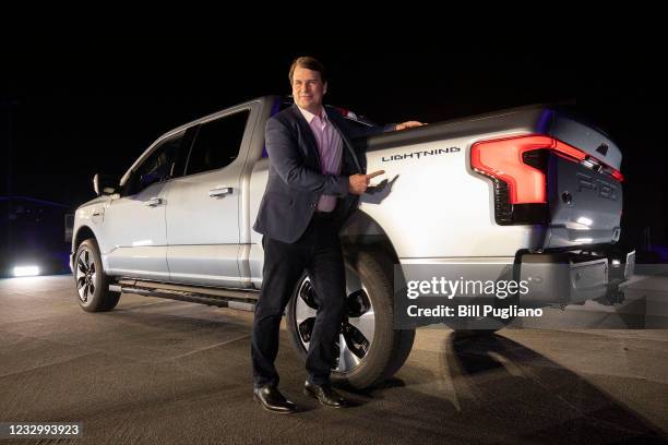 Jim Farley, CEO of Ford Motor Company, poses with the new all-electric F-150 Lightning performance truck at its reveal at Ford World Headquarters on...