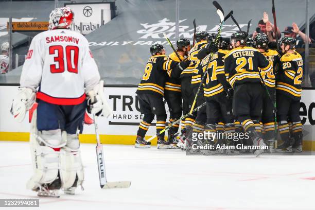 Ilya Samsonov of the Washington Capitals looks on as Craig Smith of the Boston Bruins reacts with teammates after scoring the game-winning goal in...