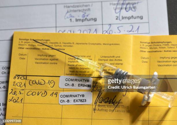 This illustration photo shows a vaccination pass with the entry of a 2nd vaccination of Pfizer/BioNTech and a medical syringe, on May 20, 2021 in...