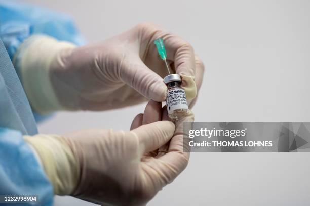 Nurse shows an empty vial of the Pfizer Biontech vaccine Comirnaty at the vaccination center of German speciality chemicals company Evonik in Hanau,...