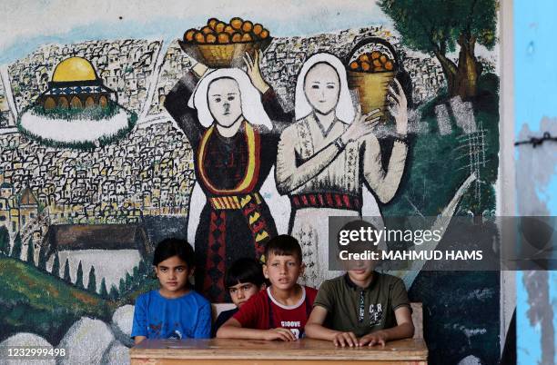 Palestinian boys are pictured in front of a mural at an UNRWA school where several families sought refuge from Israeli air strikes in Gaza City, on...