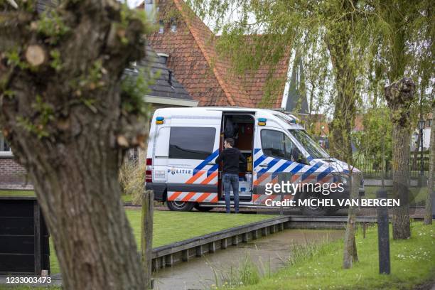 Dutch police offcier inspects the scene where the suspects of an armed robbery was chased the day before, in Broek in Waterland on May 20, 2021. -...