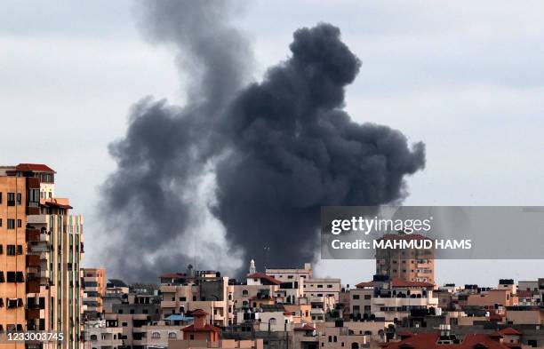 Smoke billows above buildings during an Israeli air strike on Gaza City's Rimal neighbourhood, on May 20, 2021. - Israel and the Palestinians are...