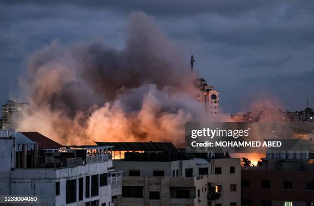 Smoke billows above buildings during an Israeli air strike on Gaza City, on May 20, 2021. - Israel and the Palestinians are mired in their worst...