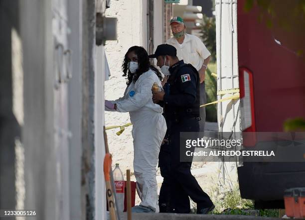 Forensic worker and a policeman enter the house of alleged serial killer Andres "N", who was detained a few days ago, in the municipality of Atizapan...