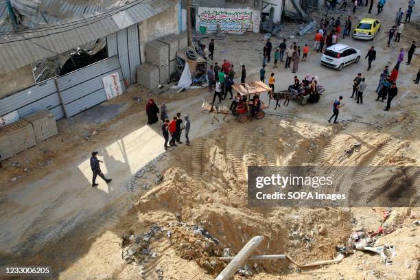 Palestinians seen around a crater where a bomb exploded after Israeli air strikes in Jabaliya refugee camp. Israel and the Palestinians are mired in...