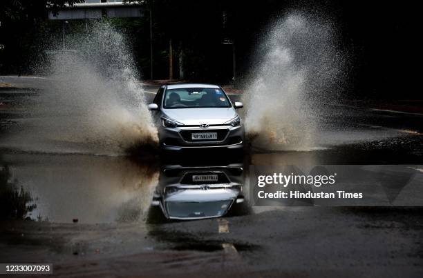 Water splashes as a car moves through the waterlogged road at Bahiron Marg after day and night rain on May 20, 2021 in New Delhi, India. Delhi on...