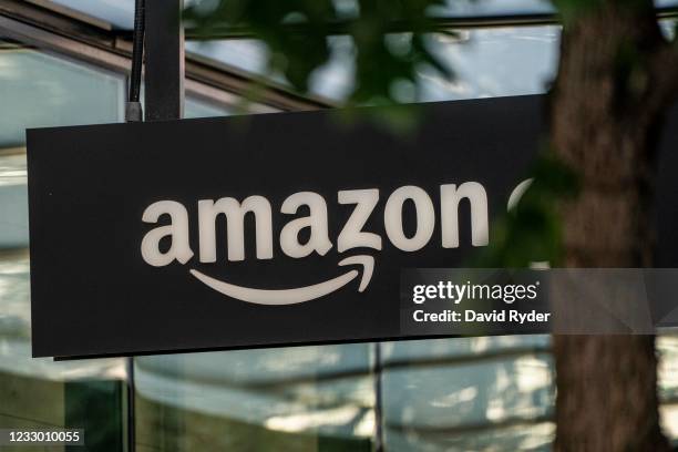 Sign is seen outside of an Amazon Go store at the Amazon.com Inc. Headquarters on May 20, 2021 in Seattle, Washington. Five women employees sued...