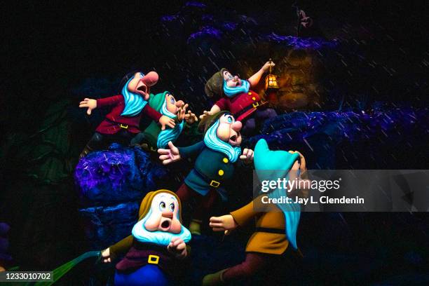 The seven Dwarfs caught in a rain storm as darkness descends on Snow Whites Enchanted Wish ride at the Disneyland Resort in Anaheim, CA, as visitors...