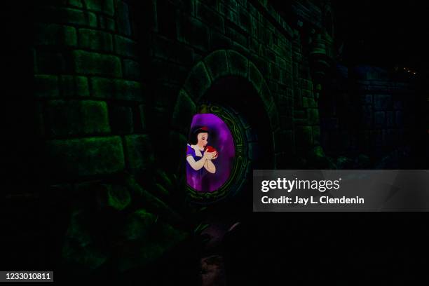 Snow White prepares to bite into an apple poisoned by the Evil Queen, on Snow Whites Enchanted Wish ride at the Disneyland Resort in Anaheim, CA, as...