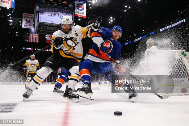 Kris Letang of the Pittsburgh Penguins and Anthony Beauvillier of the New York Islanders chase down a loose puck during the second period in Game...