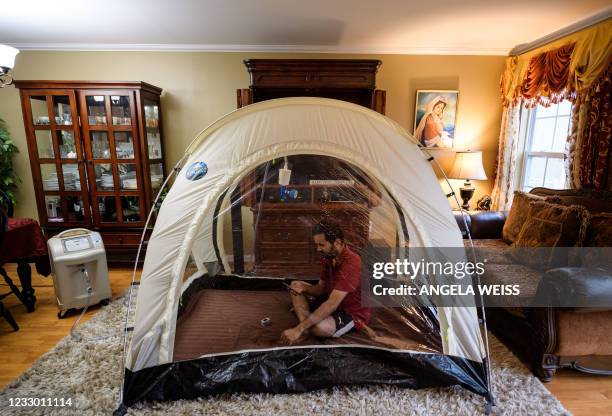 Akash Negi sits in a hypoxic tent, a low-oxygen tent that mimics thin air at high altitude, on April 15 in Parlin, New Jersey, as he prepares for his...