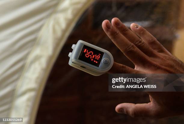 Akash Negi uses a pulse oximeter on April 15 in Parlin, New Jersey, as he prepares for his expedition to summit Mount Everest. Mountaineer Akash...