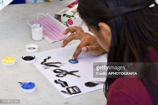 Child paints with their fingers on a piece of paper as part of a mental health program of Doctors Without Borders amid the COVD-19 pandemic on May...