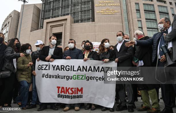 Members of the "Taksim Solidarity Platform" group hold a banner reading "Gezi protests cannot be judged" as they gather outside the Istanbul's...