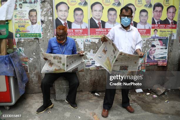 Reader reacts to the camera while hold a newspaper in Dhaka, Bangladesh on May 18, 2021.