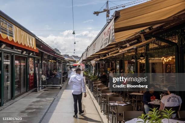 Restaurant worker tends to customers dining at an outside area of a restaurant in the Naschmarkt in Vienna, Austria, on Thursday, May 20, 2021....