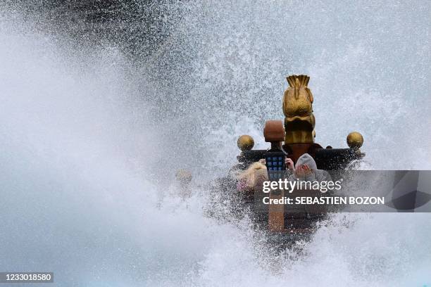 Visitors ride through a watersplash on a rollercoaster at Europa Park in Rust, western Germany on May 21 on the re-opening day of the centre...