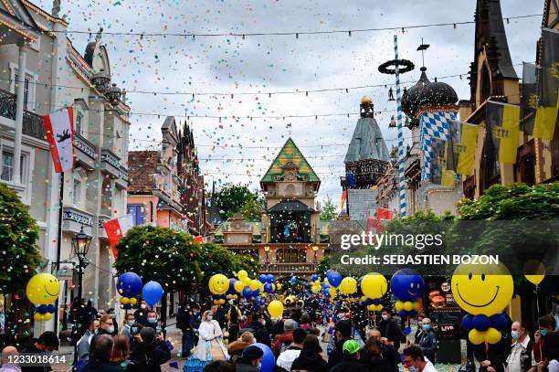 Employees welcome visitors as they enter Europa Park in Rust, western Germany on May 21 on the re-opening day of the centre following the lifting of...