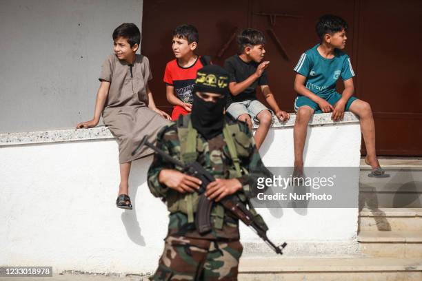 Palestinian children look on as Islamic Jihad militants stand guard following Israel-Hamas truce, in Gaza May 21, 2021.