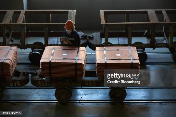 Worker wearing a protective face mask performs an inventory check on newly-made copper cathode sheets before they are moved from the electrolysis...