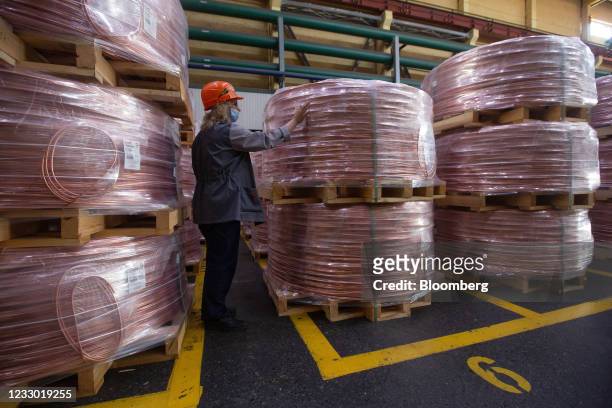 Worker inspects packaged copper wire rod in a storage facility following manufacture at the Uralelectromed Copper Refinery, operated by Ural Mining...