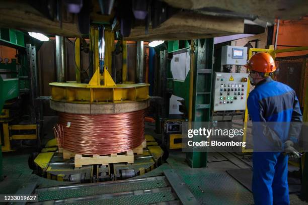 Worker monitors as a machine compresses a spool of copper wire rod following manufacture at the Uralelectromed Copper Refinery, operated by Ural...