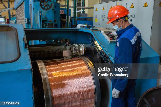 Worker monitors a machine as it spools copper wire rod following manufacture at the Uralelectromed Copper Refinery, operated by Ural Mining and...