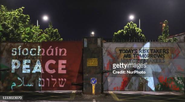 The word 'peace' in Irish, English, Arabic and Hebrew projected at the Lanark Way peace gates in Belfast, as part of the Herstory's new Parallel...