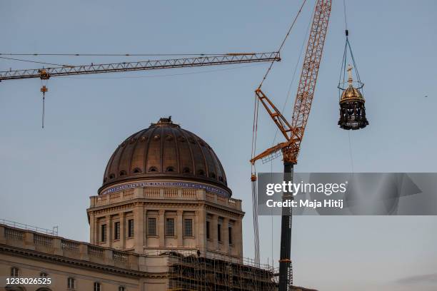 Crane lifts the newly-finished gold-covered cupola and cross onto the dome of the rebuilt Berlin City Palace on May 29, 2020 in Berlin, Germany. The...