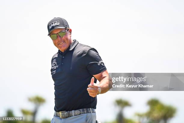 Phil Mickelson smiles and gives a thumbs up to fans after making a birdie putt on the ninth hole green during the second round of the PGA...