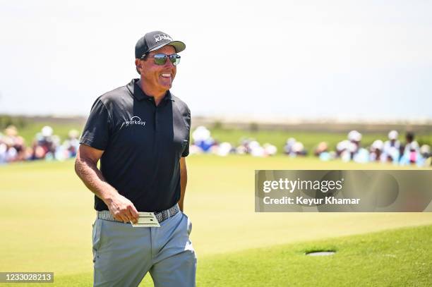 Phil Mickelson smiles with his scorecard in hand after making a birdie putt on the ninth hole green during the second round of the PGA Championship...