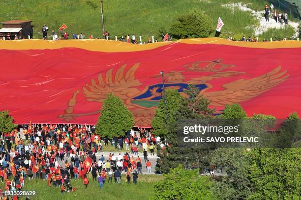 People hold a 5000 square meter giant flag of Montenegro during a celebration marking the 15th anniversary of the Independence in Cetinje on May 21,...