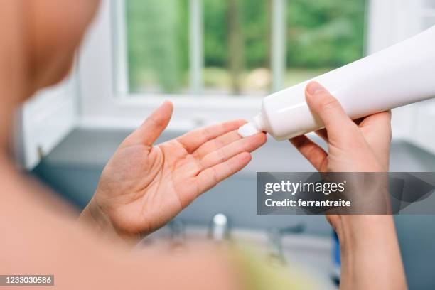 ハンドクリームを適用する女性 - 乳液 ストックフォトと画像